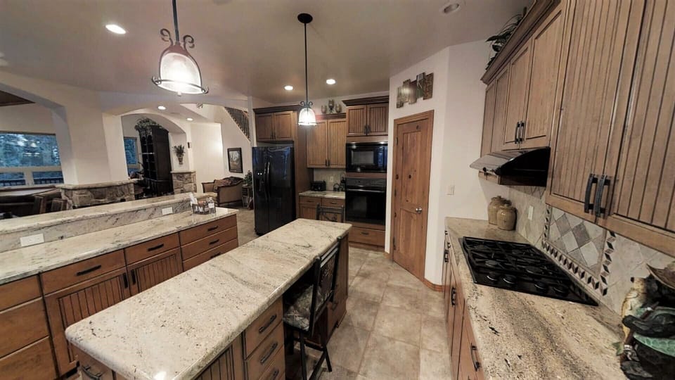 Gather around the spacious gourmet kitchen with granite countertops, modern appliances, and a large center island—perfect for preparing meals and making memories together during your stay.