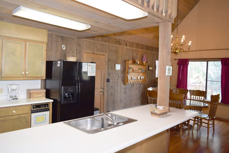 Your spacious mountain retreat features a fully-equipped kitchen with modern appliances, a large island for meal prep, and a cozy dining area where you can gather for hearty meals.