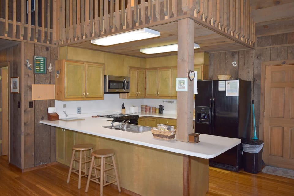 Your fully equipped kitchen features modern appliances, ample counter space, and a convenient breakfast bar—perfect for preparing meals and gathering with loved ones during your mountain retreat.
