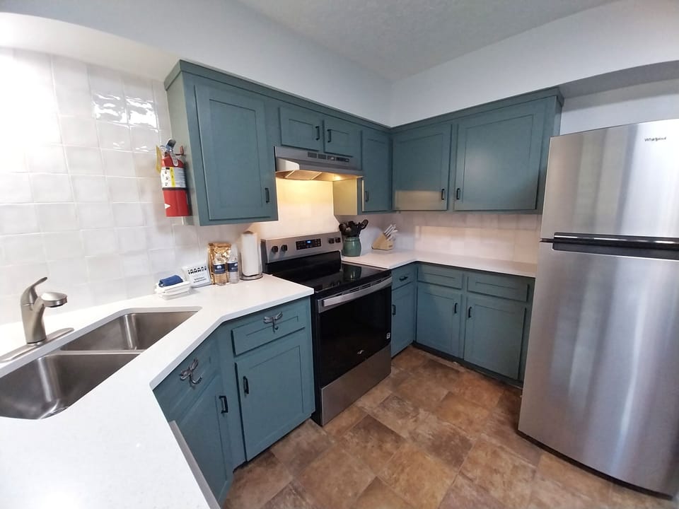 Your charming kitchen features sage-blue cabinetry, modern stainless appliances, and all the essentials for whipping up meals during your stay.