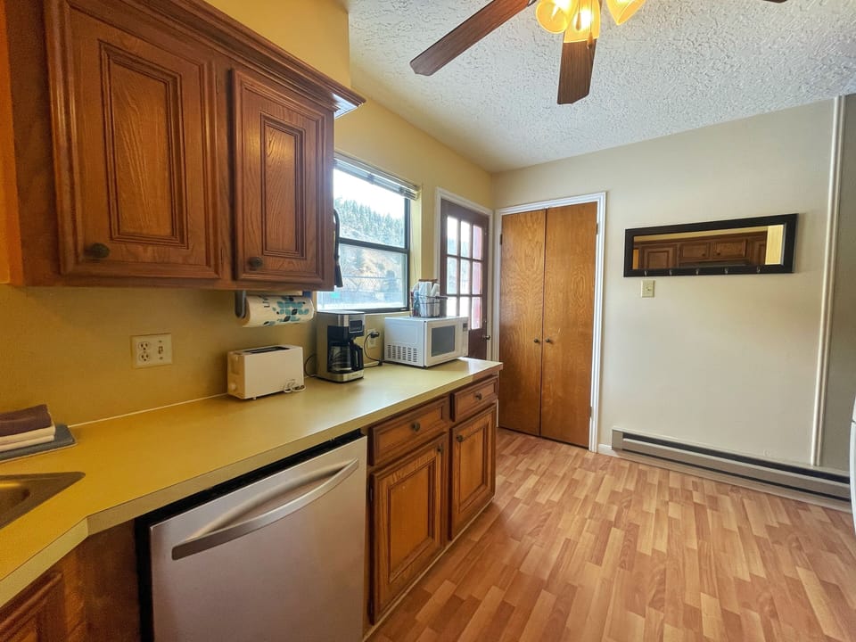 Your fully equipped kitchen features warm wood cabinetry, modern appliances including a dishwasher, and everything you need to prepare meals during your stay.
