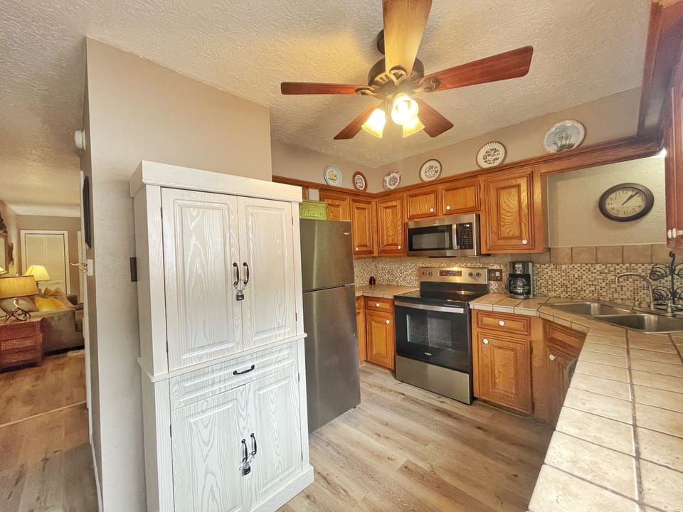 Your fully equipped kitchen awaits with modern appliances, warm wood cabinetry, and charming decor—everything you need to prepare meals during your stay.