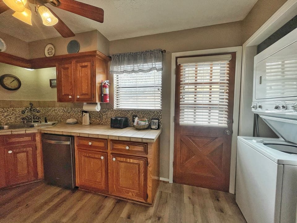 Your fully equipped kitchen features rich wood cabinetry, modern appliances, and a cozy breakfast nook—perfect for whipping up morning coffee or home-cooked meals during your stay.