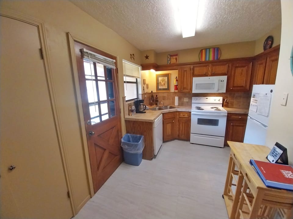 Your fully equipped kitchen invites you to prepare meals with ease, featuring warm wood cabinetry, modern appliances, and plenty of counter space for cooking or gathering over morning coffee.