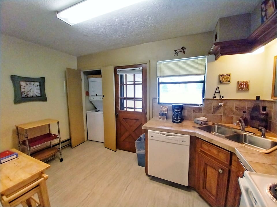 Your fully equipped kitchen welcomes you with warm wood cabinetry, modern appliances, and a skylight that fills the space with natural light—perfect for preparing meals during your stay.