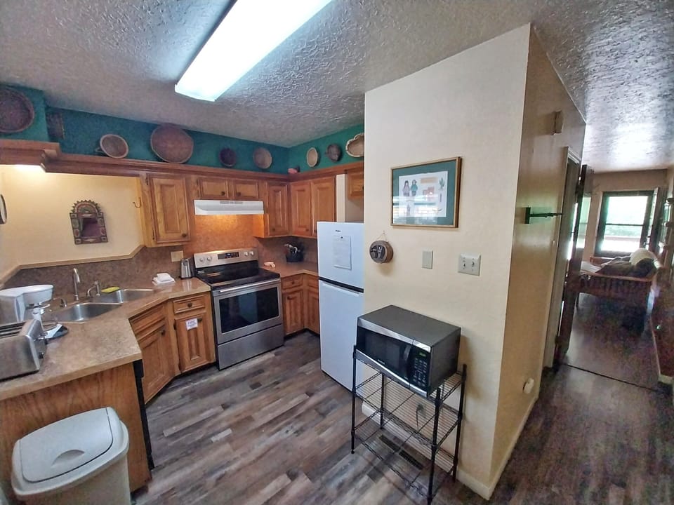 Step into your fully equipped kitchen with everything you need to cook your favorite meals, featuring warm wood cabinetry, modern appliances, and a cozy, inviting atmosphere that makes you feel right at home.