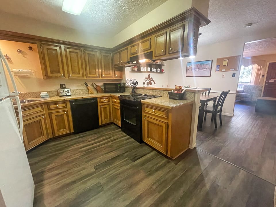 Your fully equipped kitchen features warm wood cabinetry, granite countertops, and modern appliances—everything you need to prepare meals and gather comfortably during your stay.