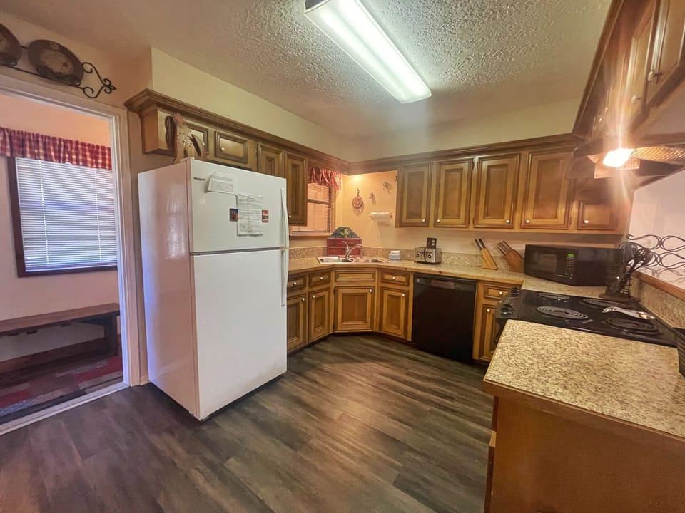 Your fully equipped kitchen invites you to prepare home-cooked meals with ample counter space, modern appliances, and warm wood cabinetry—perfect for cozy mornings or gathering over dinner.
