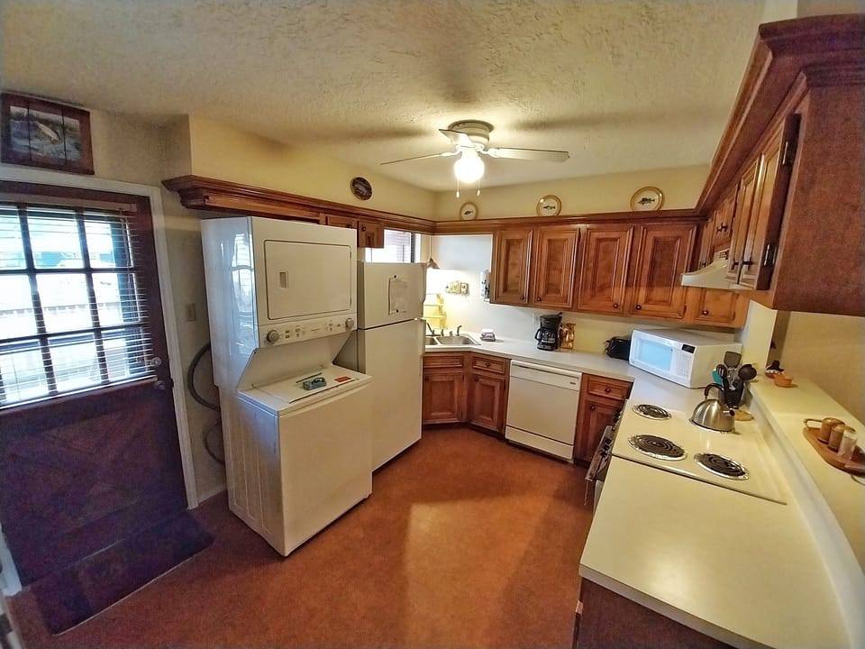 Your fully equipped kitchen has everything you need—warm wood cabinets, modern appliances, coffee maker ready to brew, and even a washer-dryer for your convenience during your stay.
