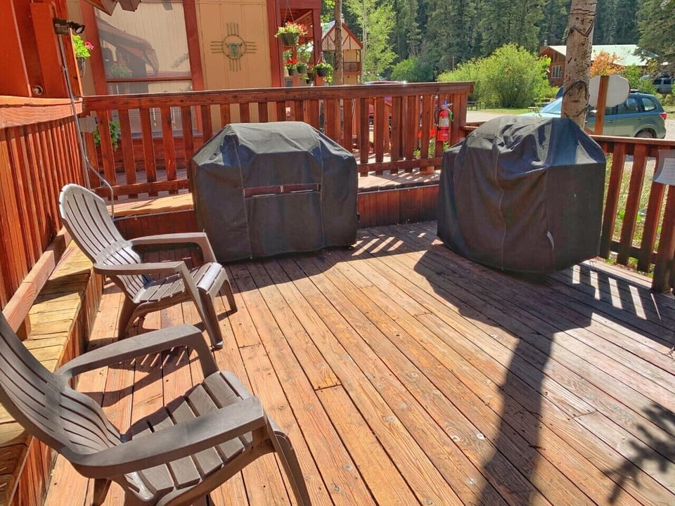 Your private deck features comfortable seating and two covered grills, ready for mountain-air BBQs with forest views surrounding you.