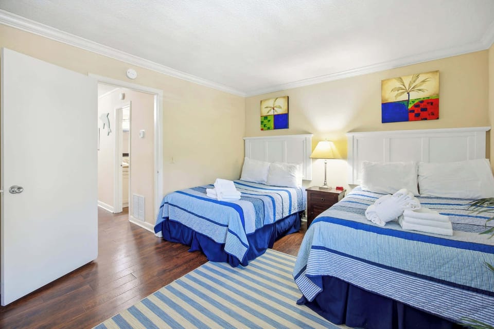 Two comfortable beds with blue striped bedding in a bright, inviting room.