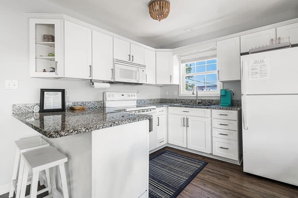 Bright, modern kitchen with granite countertops and cozy breakfast bar