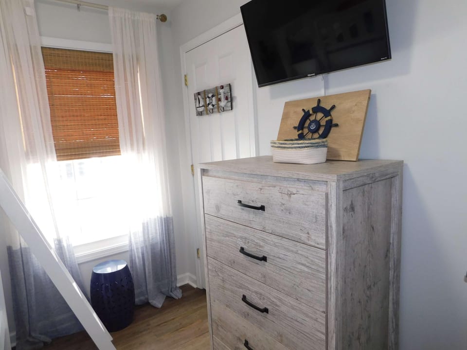 Cozy bedroom corner with natural light and smart TV viewing
