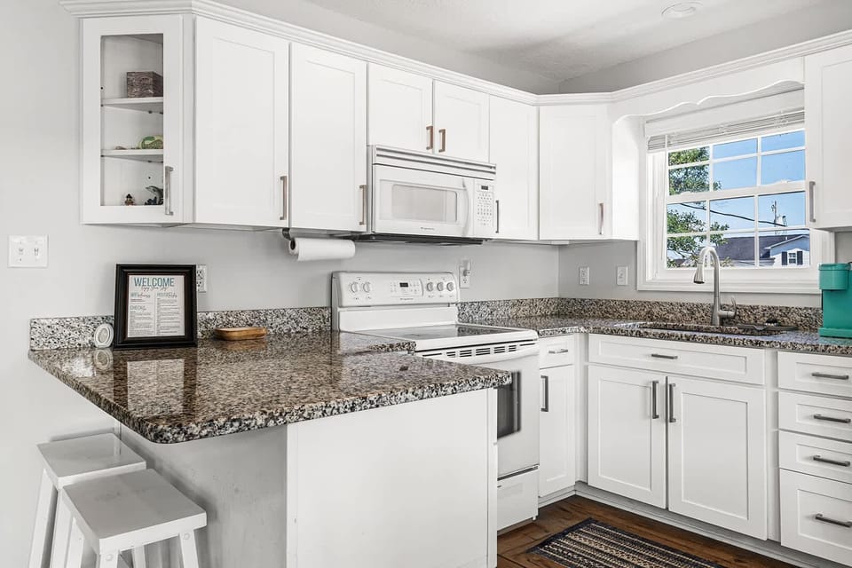 Bright, modern kitchen with granite countertops and cozy breakfast bar