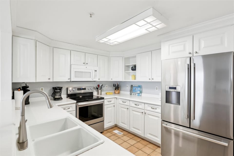 35 Kings Grant, Fenwick Island - Kitchen - Updated kitchen with white cabinetry, stainless steel appliances, and a large French-door refrigerator.