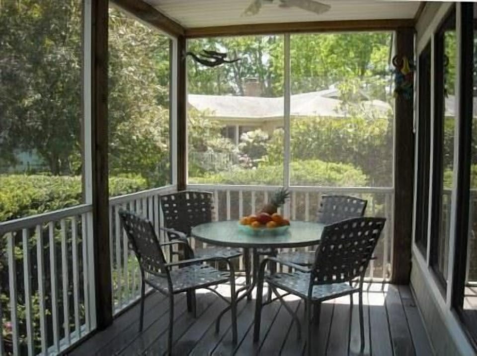 612 Paget Court - Private Screened Porch - A large screened-in porch provides a bug-free environment for outdoor dining and relaxation. Furnished with a central table and comfortable seating, it serves as an excellent extension of the interior living space during the warmer months.