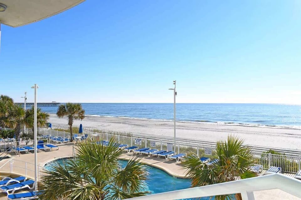 - Resort pool deck overlooks the sandy beach and Atlantic waves   - Lounge chairs surround the pool for sunny relaxation all day   - Perfect place to swim and unwind with breathtaking views