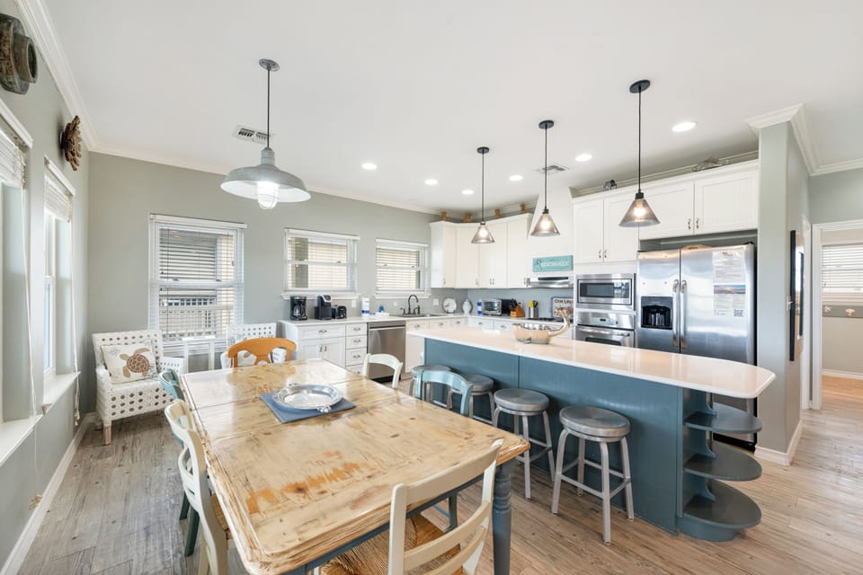 Step into your spacious kitchen where coastal charm meets modern convenience, complete with island seating and dining table for memorable meals together.