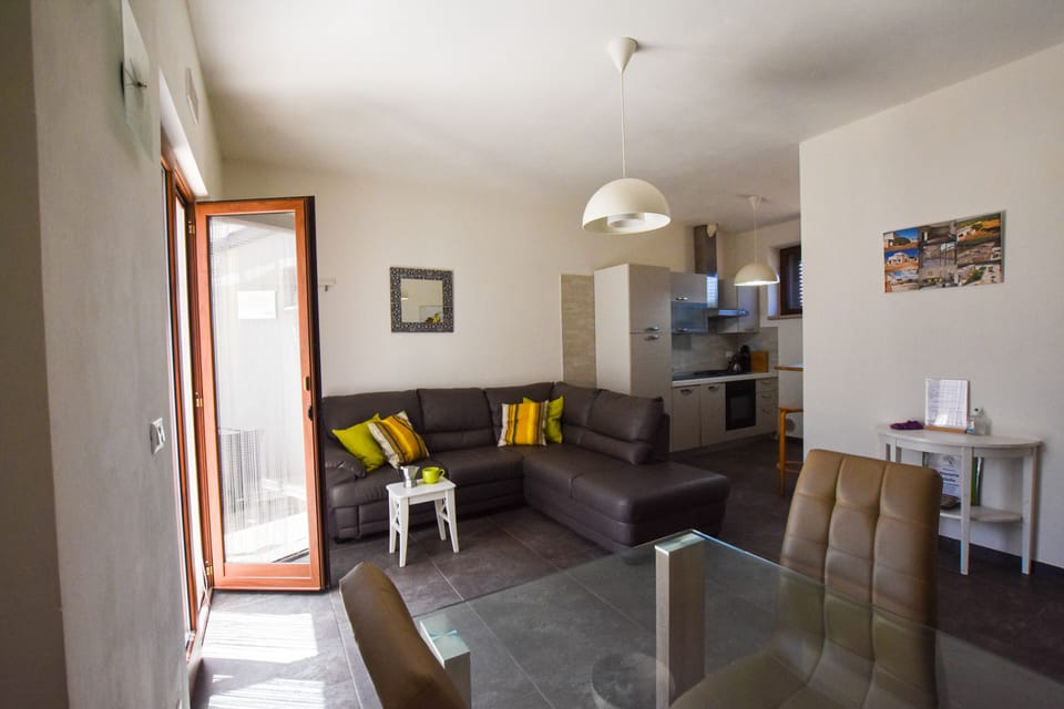 Living room with dining table, kitchen, breakfast bar and seating area