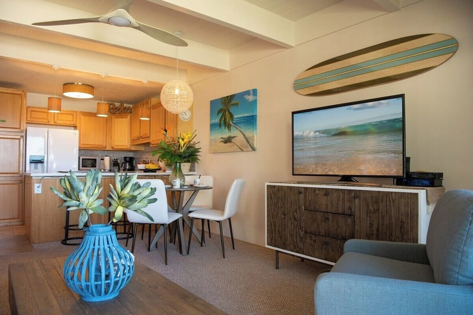 A dining nook with surfboard art and beach‑house charm, perfect for meals and movie nights.