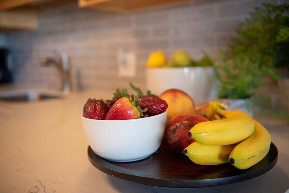 A fresh kitchen counter with colorful fruit, where island living begins with vibrant flavors.