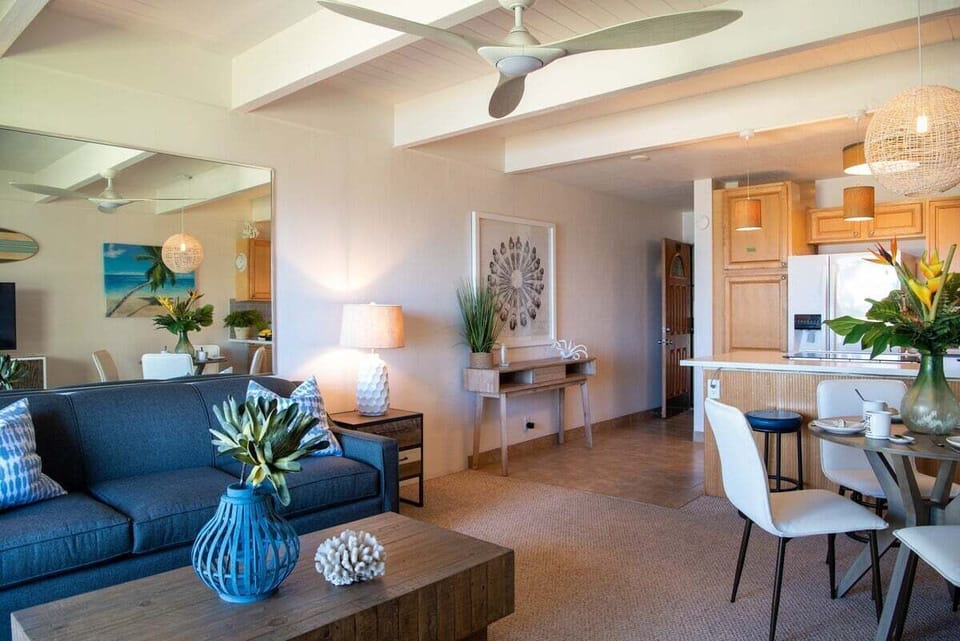 A cozy living room with coastal artwork and a comfy blue couch, perfect for unwinding after a day by the sea.