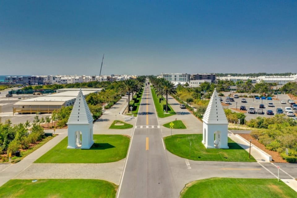 Aerial view of the scenic community entrance with distinctive white towers and manicured grounds welcoming visitors to this charming residential area.