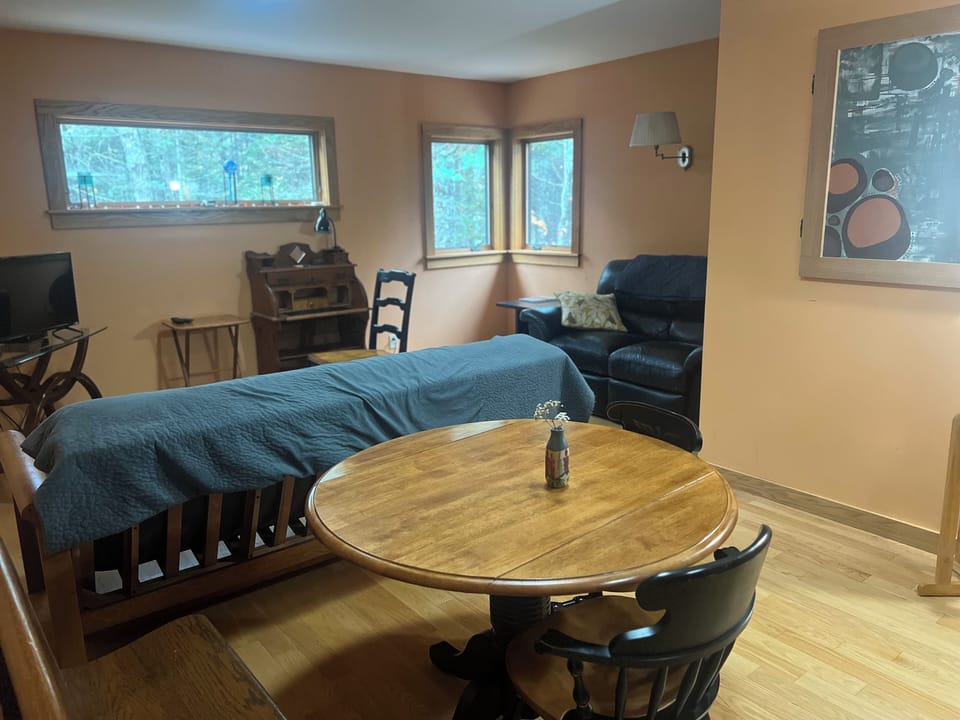 THE DINING AREA WITH VIEW TOWARDS WINDOWS AND SECOND COUCH