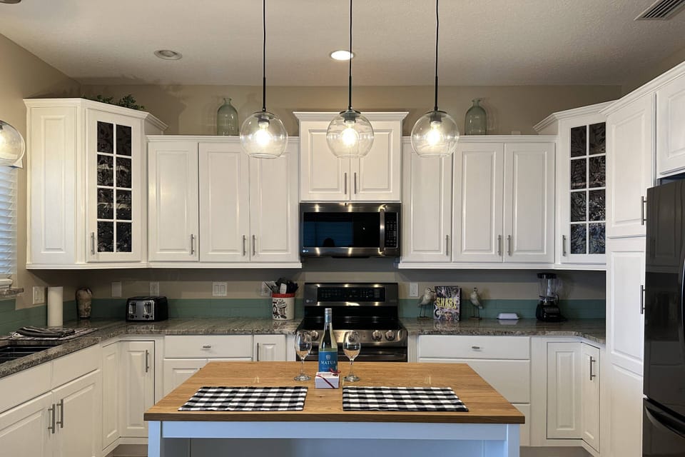 Fully equipped kitchen featuring an oven, stove, island, dishwasher, toaster, microwave, and coffee maker for your convenience.