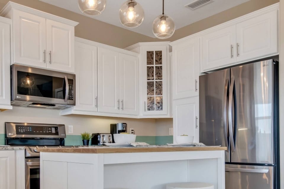 Fully equipped kitchen featuring an oven, stove, island, dishwasher, toaster, microwave, and coffee maker for your convenience.
