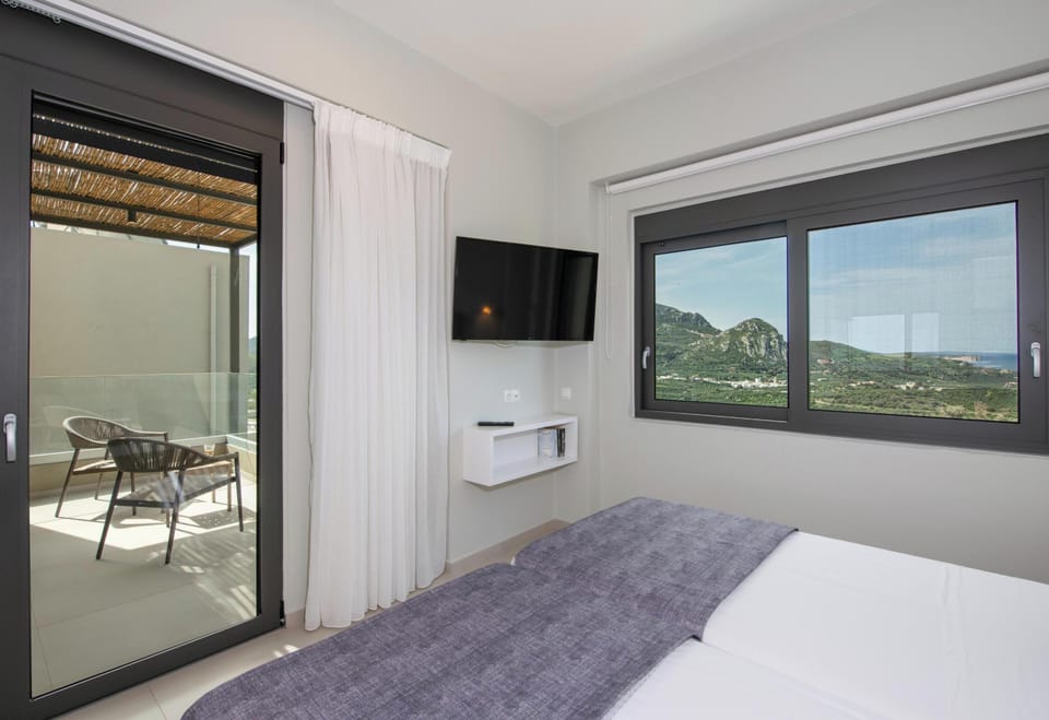 This bedroom also features an Ensuite bathroom with a stand-alone shower, air conditioning, a 43” TV, an open closet, and a shared balcony with a mountain view.