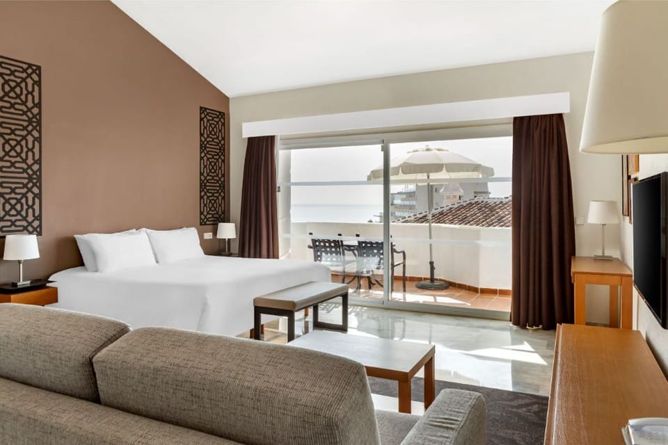 Luxuriously appointed suite with expansive windows, offering panoramic views and a plush seating area.