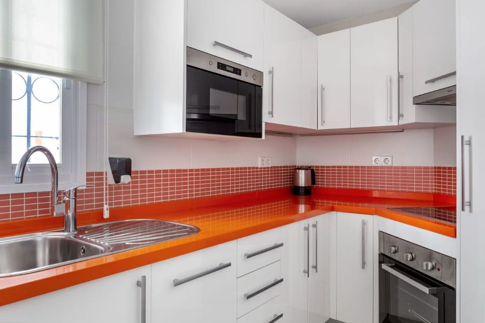 Bold and vibrant kitchen with red accents, fully equipped for culinary enthusiasts.