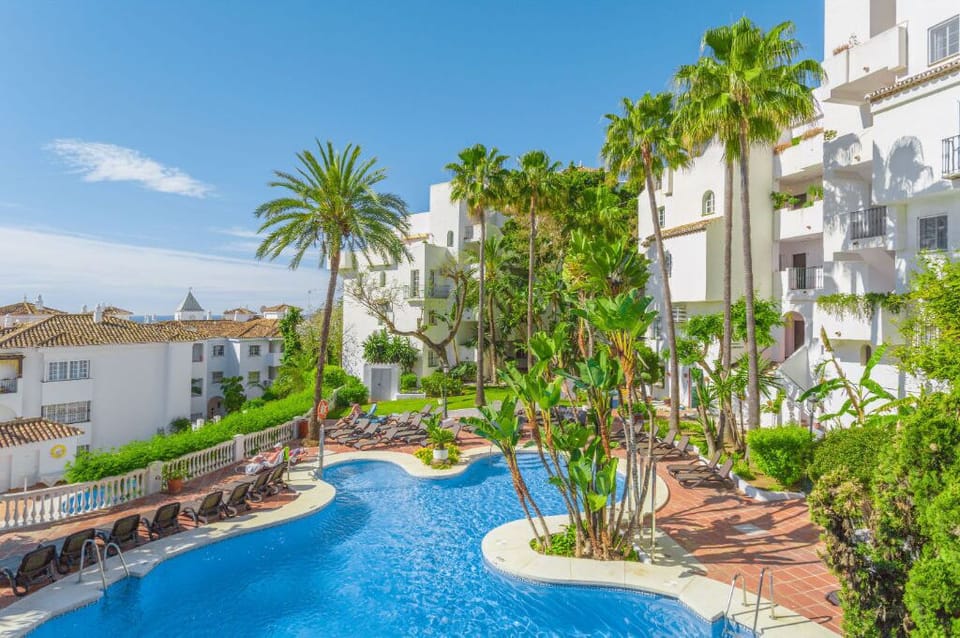 Navigate the curving pathways of a lagoon-like pool, nestled in a garden paradise.