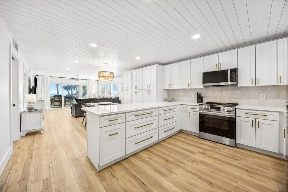 Your gourmet kitchen features sleek white cabinetry, premium appliances, and a spacious island perfect for cooking memorable meals during your stay.