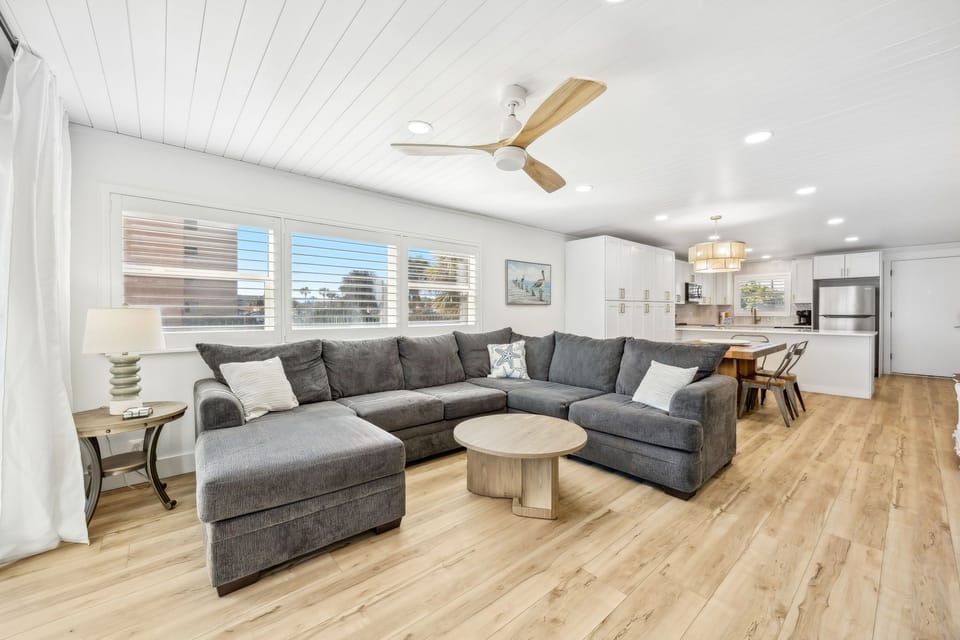Unwind in your spacious living room featuring a plush sectional sofa and open-concept design connecting seamlessly to the modern kitchen.