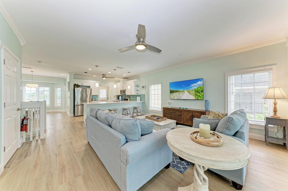 Sink into the plush sectional and unwind in this airy, open-concept living space with soft coastal hues, natural light, and your favorite shows on the big screen.
