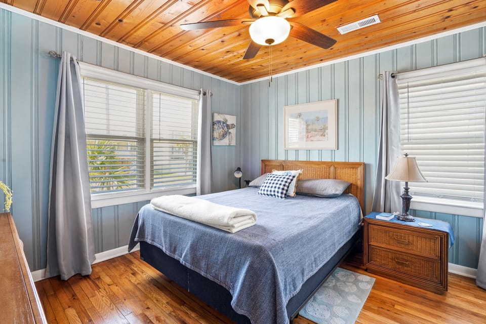 Blue-walled bedroom with a ceiling fan at Sunny Side Up, a 4-bedroom Cherry Grove rental