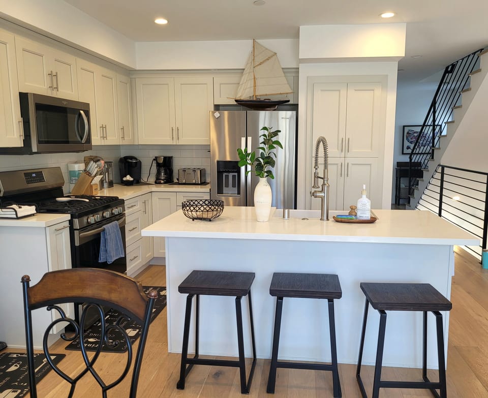 stovetop, refrigerator, coffee bar,   oven, microwave,dishwasher staircase, kitchen bar and island