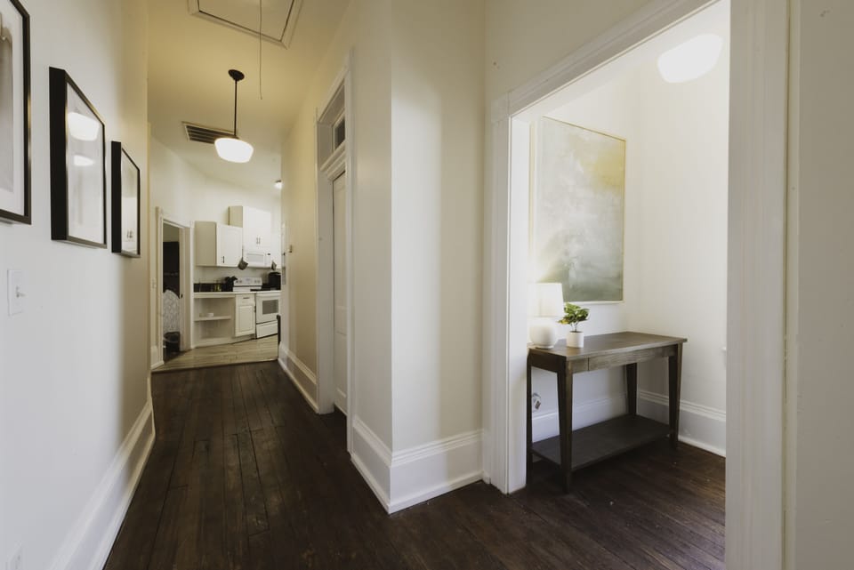 The stairs leading up to the apartment open to a high-ceilinged hallway.