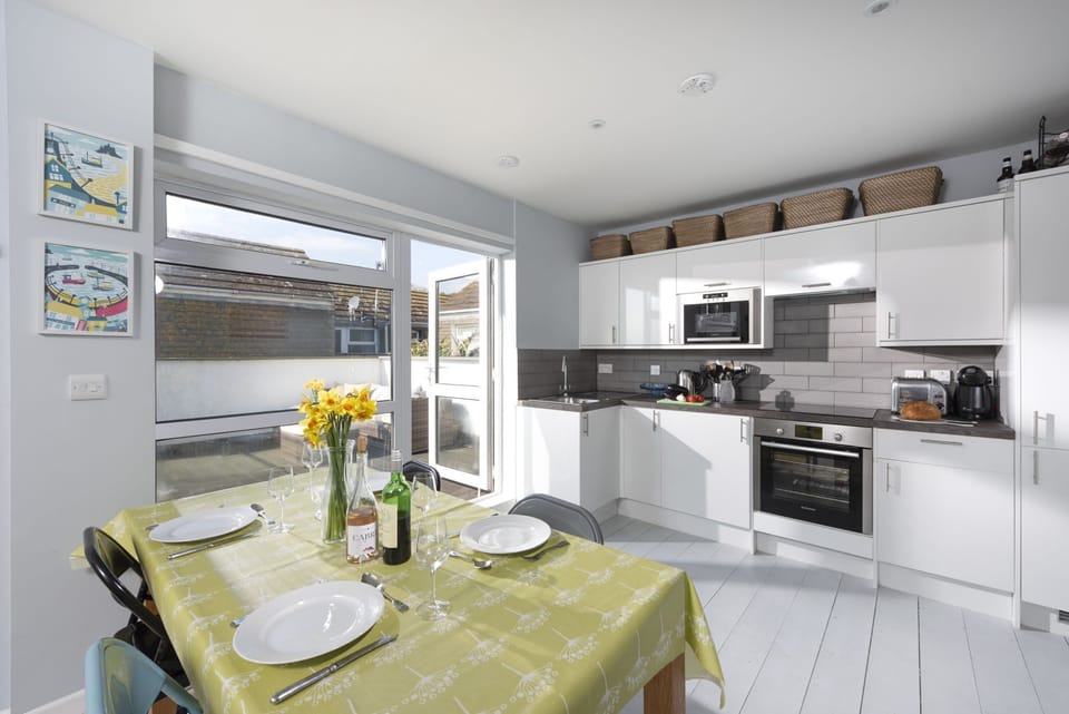 Dining and kitchen area leading to balcony - Mousehole View