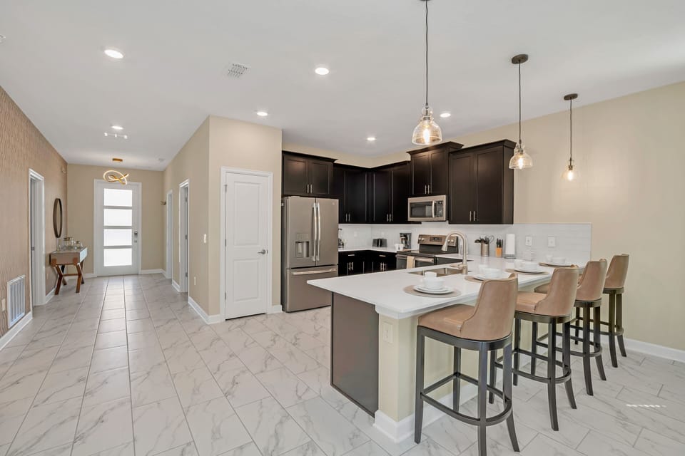 An inviting kitchen and dining setup with a stylish island and plenty of seating - Elegant lighting and spacious counters create a welcoming hub for family and friends - Perfect for everything from casual breakfasts to holiday gatherings