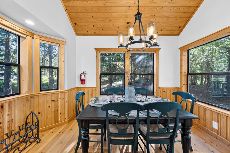 Wood-accented dining room with forest views and a warm cabin-inspired feel.