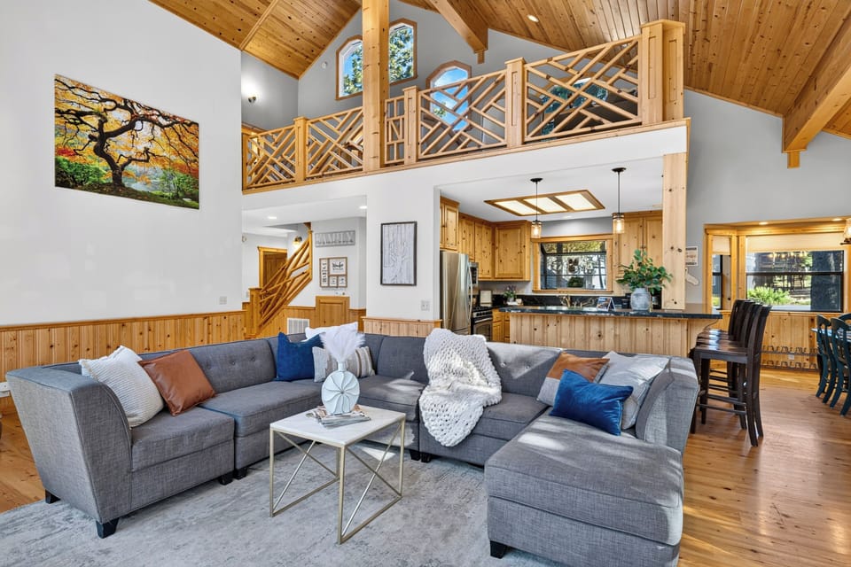 Open great room with lofted ceilings, a spacious sectional, and warm lodge-style finishes throughout.