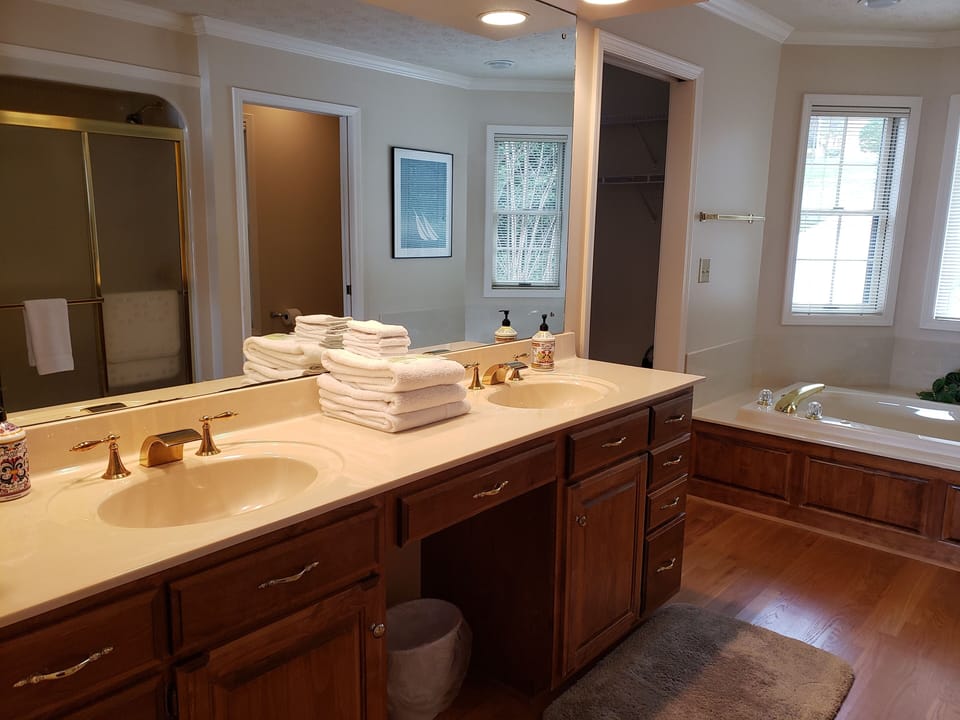 Master bathroom double sinks, with a separate toilet and walk in closet.
