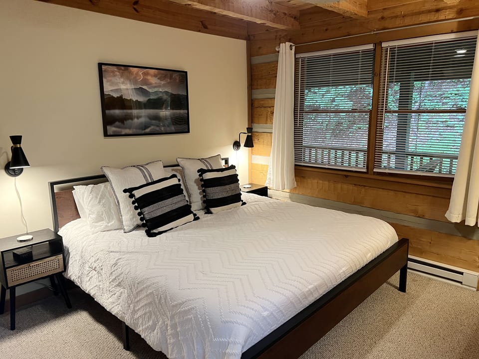 Rest easy in this cozy king bedroom at 7Th Heaven, where warm wood details and soft lighting set the perfect mountain mood.