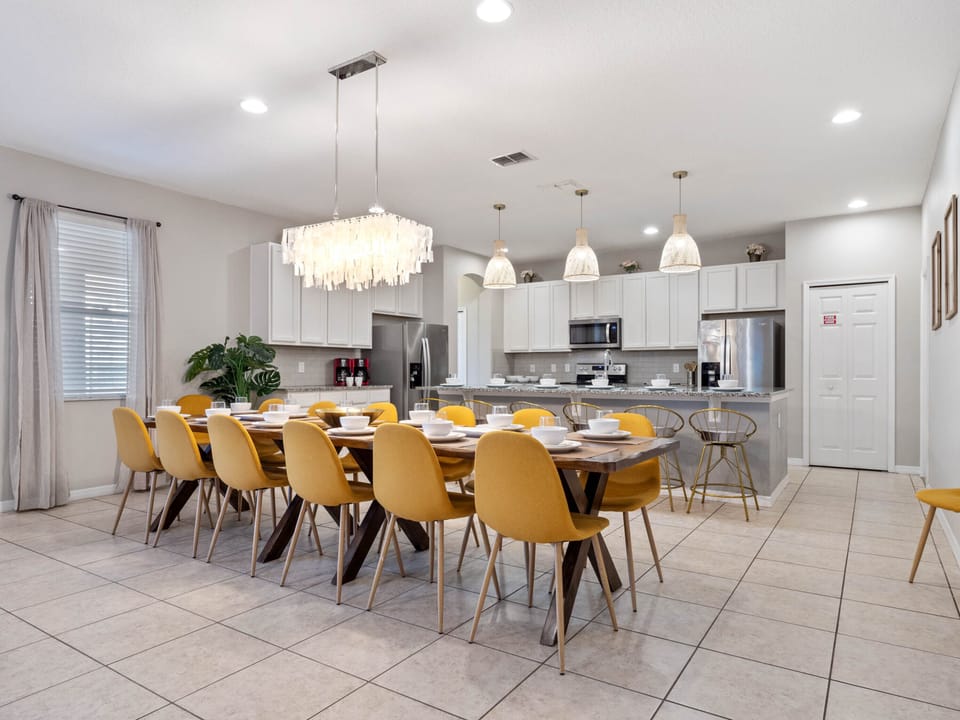 - Long dining table with stylish yellow chairs  
- Florida rental with modern lighting and décor  
- Family vacation home ready for group gatherings