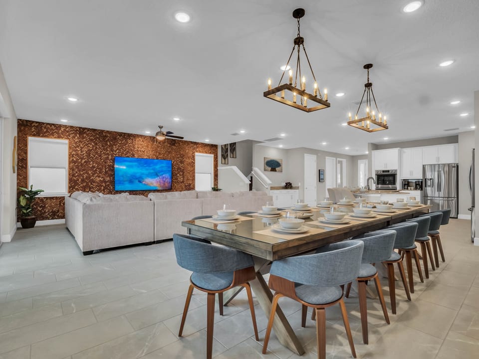 - Spacious living and dining room perfect for large group gatherings  
- Modern open layout with long dining table and stylish seating  
- Large wall mounted TV for relaxing movie nights together