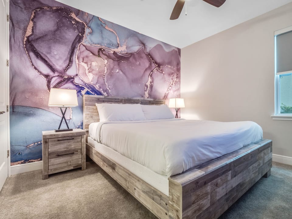 - Bedroom with rustic wood furniture and artistic accent wall design  
- Comfortable queen bed ensures restful sleep during vacation stays  
- Unique wall mural adds style to the Airbnb guest experience