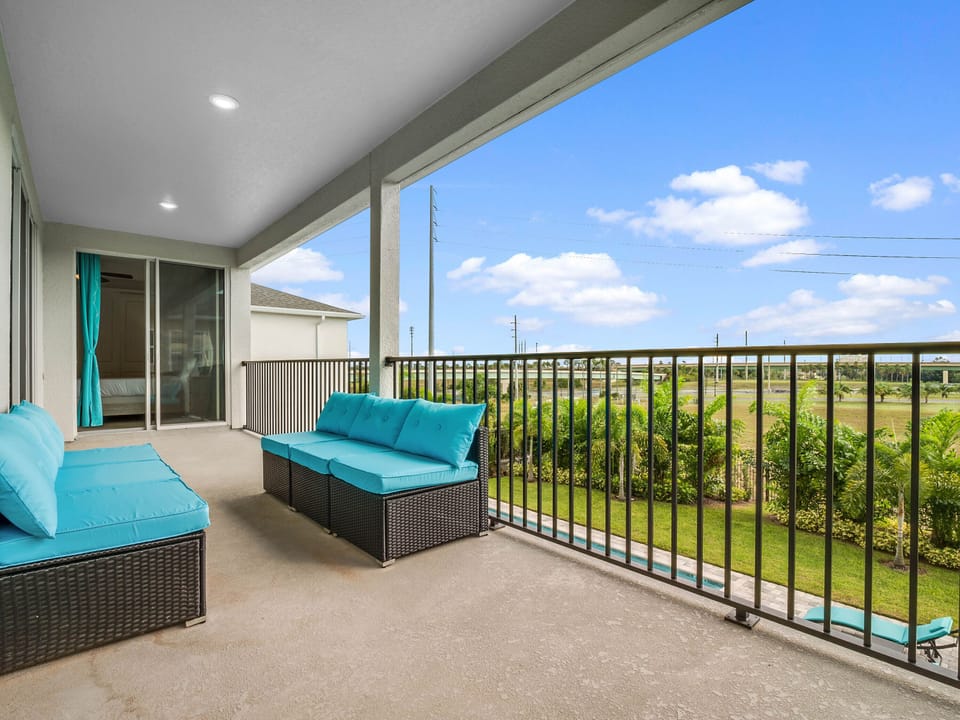 - Covered balcony with comfortable wicker seating and pool view  
- Relaxing outdoor lounge area perfect for morning coffee breaks  
- Scenic balcony setting designed for family vacation enjoyment